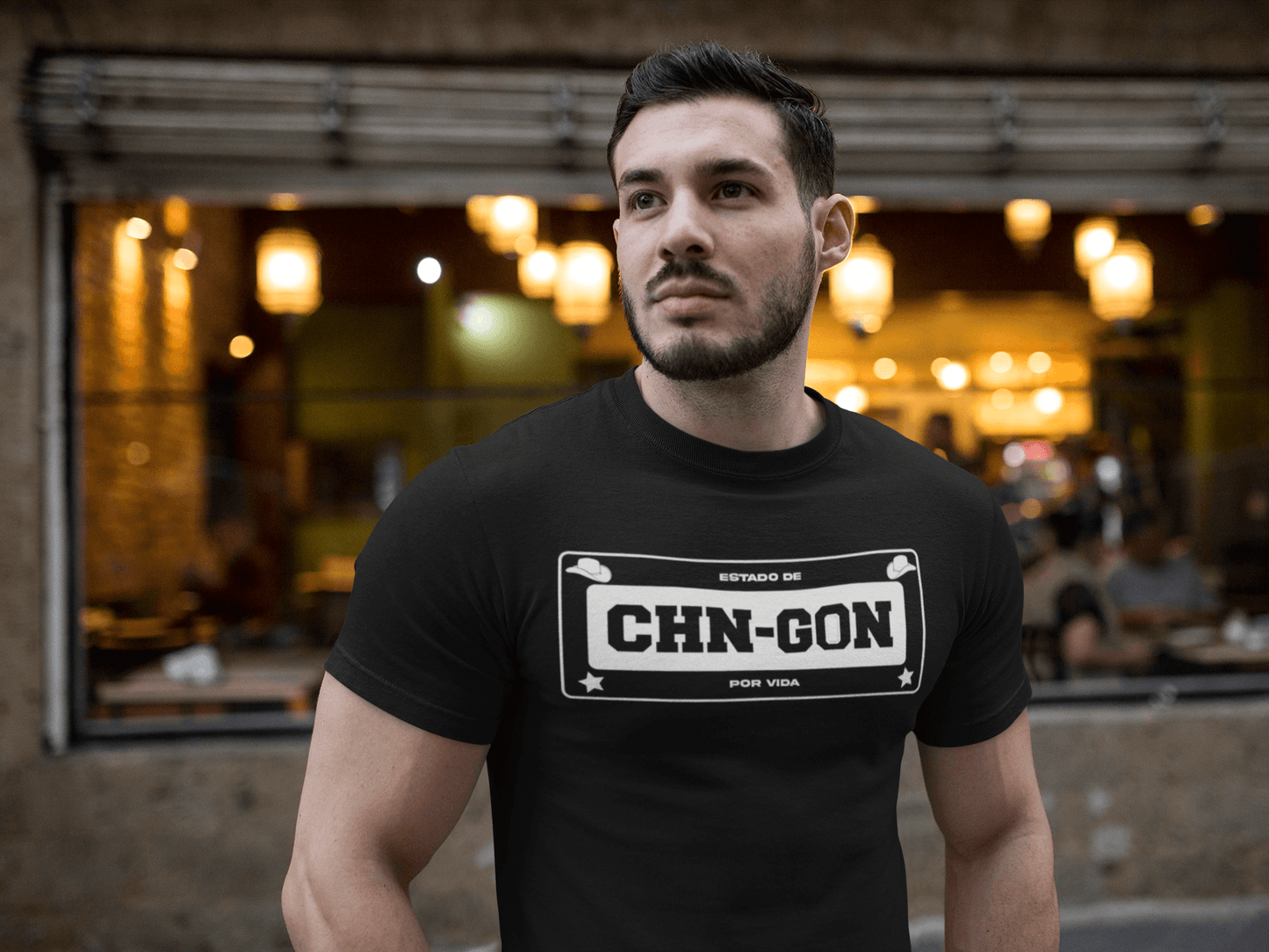 Black t-shirt with the text, "Estado de CHN-GON Por Vida" in white ink in a license plate layout. This shirt comes in sizes small thru 4XL. It is available at www.sanchezhere.com