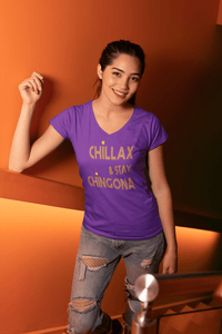 Purple V-neck t-shirt with the text, "Chillax Y Stay Chingona" in streetwear font and yellow ink. This sexy tee comes in sizes small thru 3XL. It is available at www.sanchezhere.com