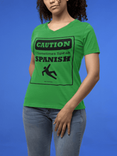 Load image into Gallery viewer, Green V-Neck t-shirt with black text and design that reads, &quot;Caution I sometimes speak Spanish #Don&#39;tTripGringos &quot; in a caution sign layout. It is available in sizes SM-3XL at www.sanchezhere.com
