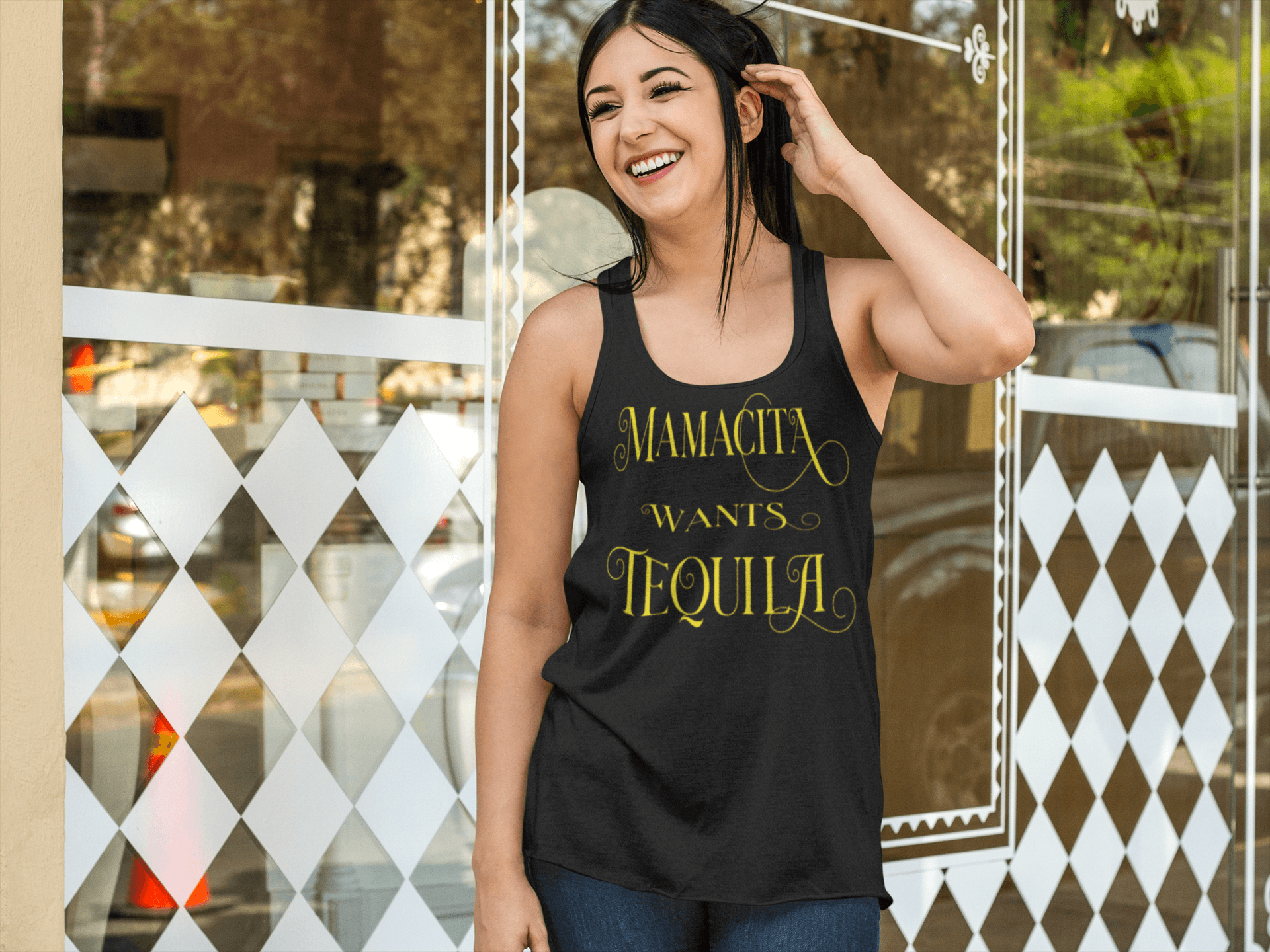 Black racerback tank with the text, "Mamacita Wants Tequila" in scriptive font and yellow ink. This sexy tee comes in sizes small thru 3XL. It is available at www.sanchezhere.com