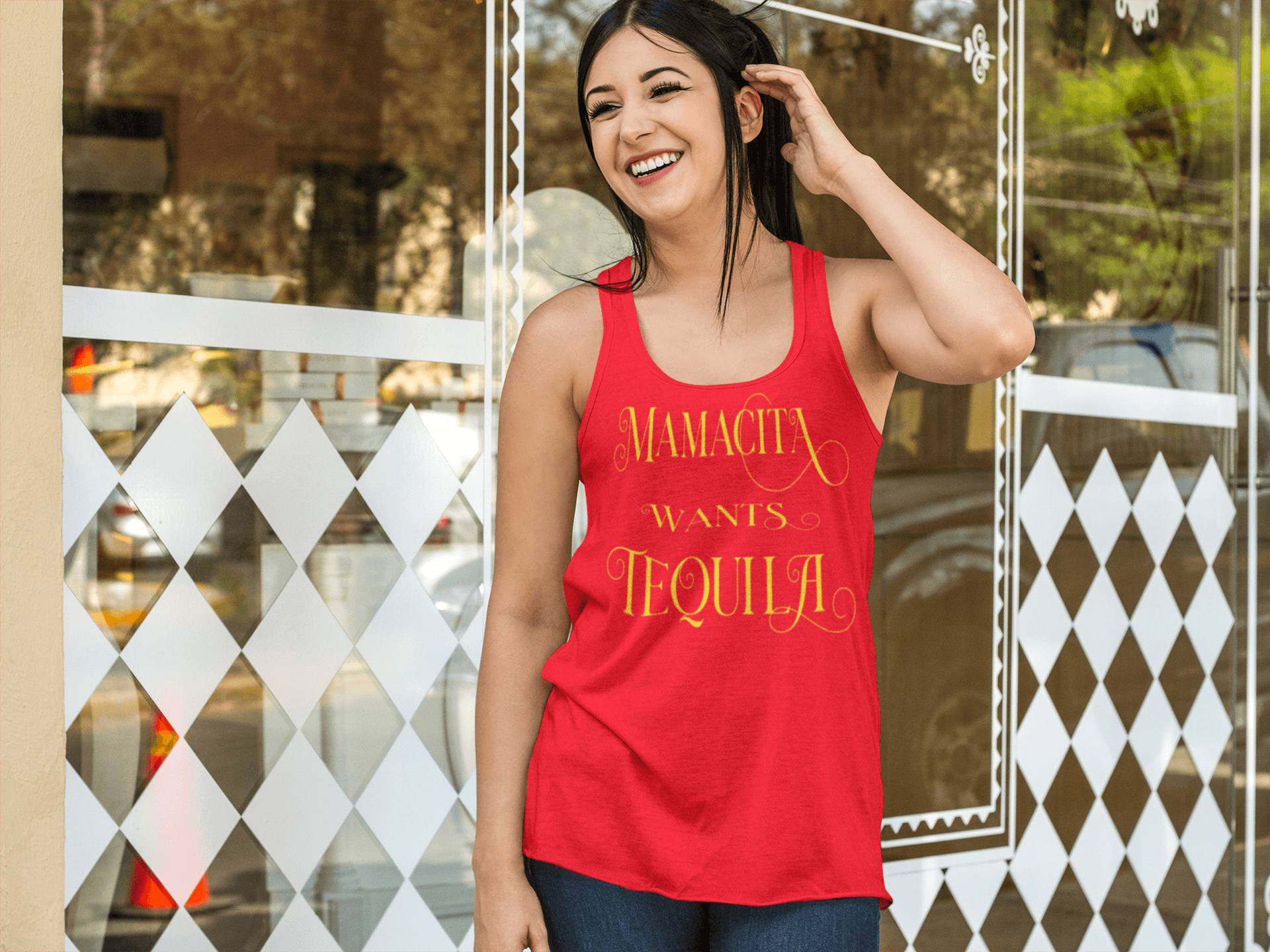 Red racerback tank with the text, "Mamacita Wants Tequila" in scriptive font and yellow ink. This sexy tee comes in sizes small thru 3XL. It is available at www.sanchezhere.com