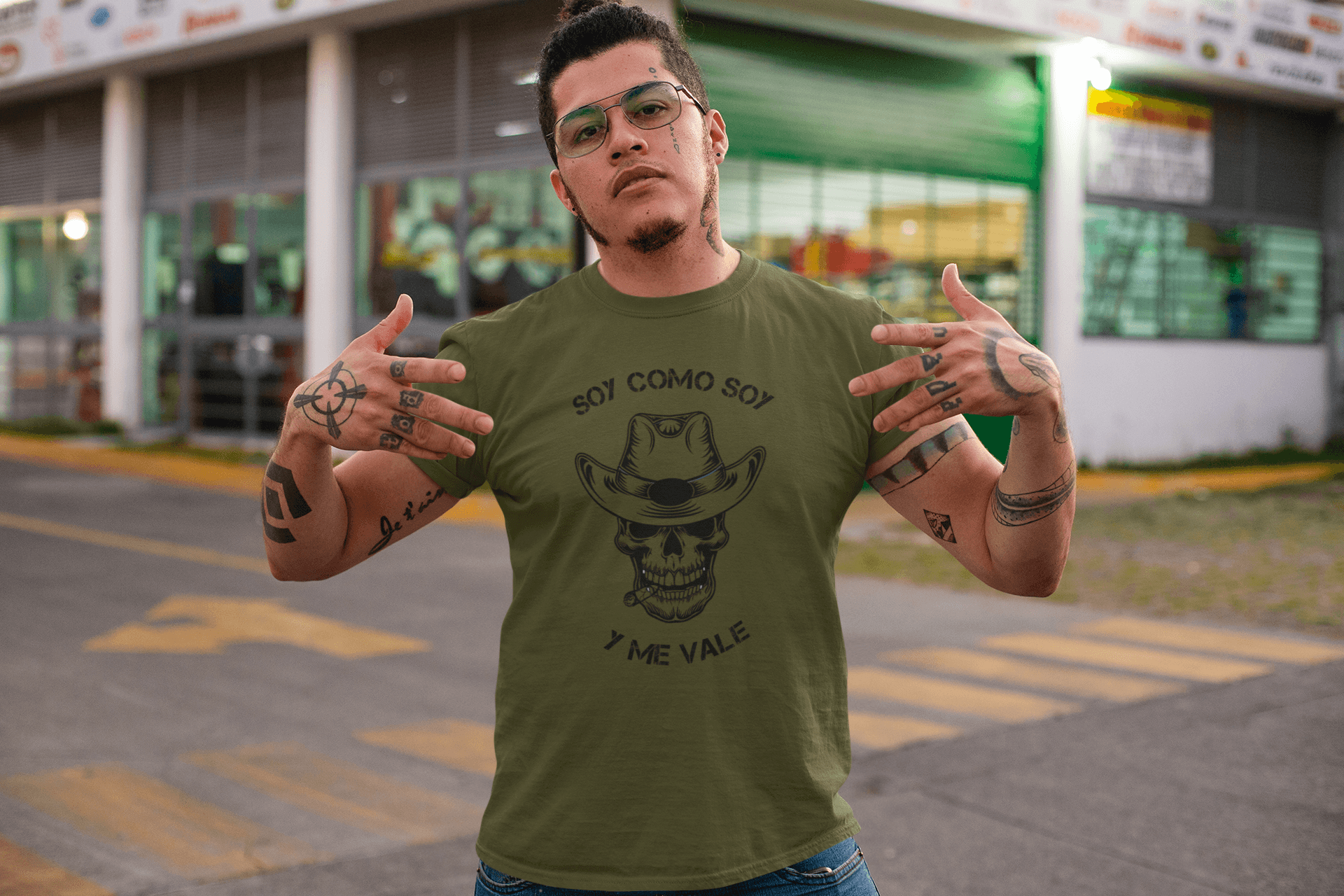 Army Green t-shirt with black text and design that reads, "Soy Como Soy Y Me Vale" and contains a skull with cowboy hat. It is available in sizes SM-4XL at www.sanchezhere.com